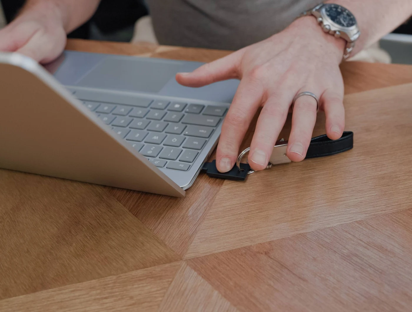 Prst dodiruje sigurnosni ključ YubiKey umetnut u bočni priključak prijenosnog računala